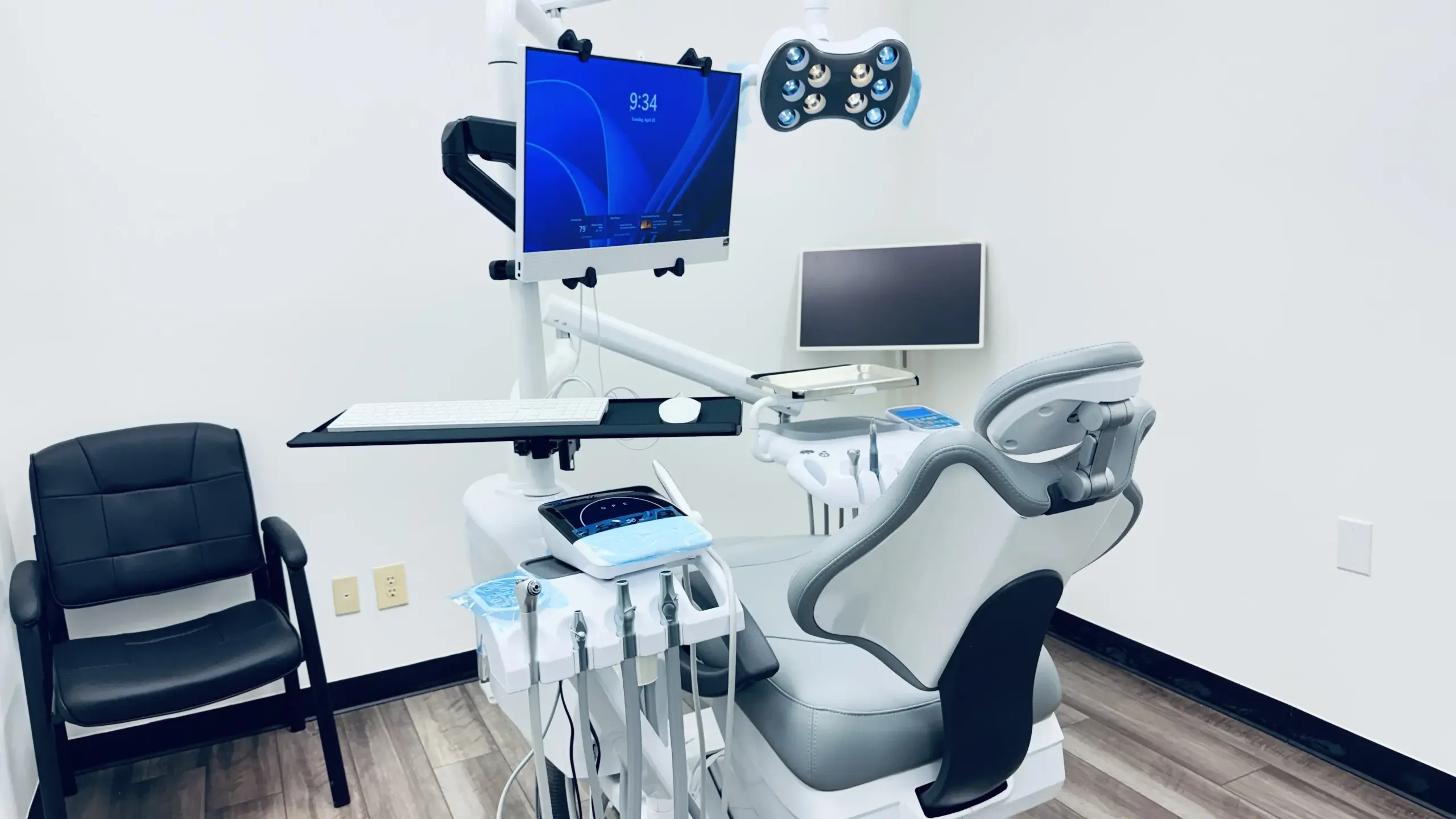 Dental treatment room with a patient chair, monitor, and dental equipment.